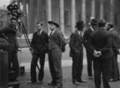 Blackmail (1929) - on location - On set photograph from ''Blackmail'', taken outside the British Museum. From L-R: unknown, Ronald Neame, unknown, Donald Calthrop, unknown, Alfred Hitchcock, unknown.